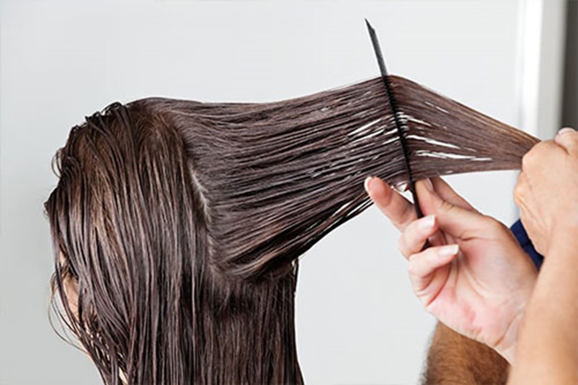 mujer cortandose el cabello